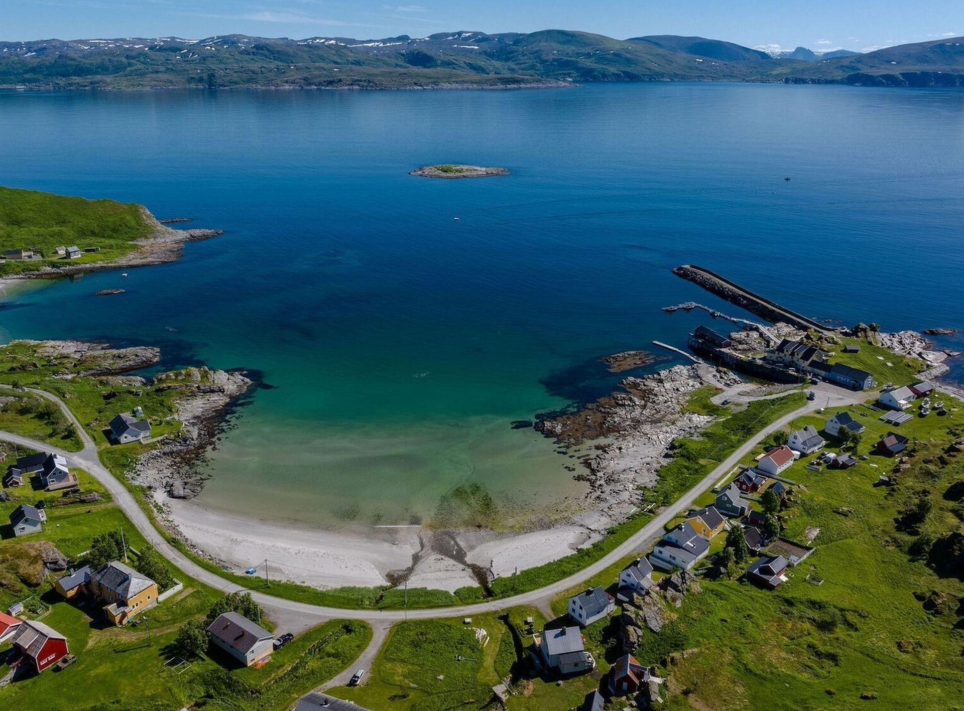 Sørøyas turkosa hav, strand och bebyggelse